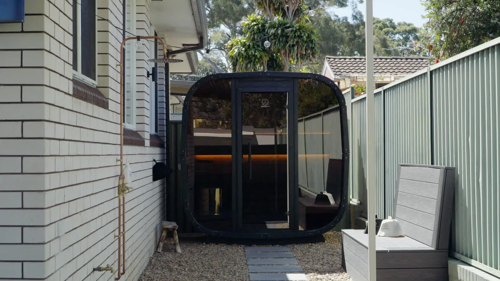 The empty Mortdale Koda sauna with its curved glass front, timber benches and warm lighting