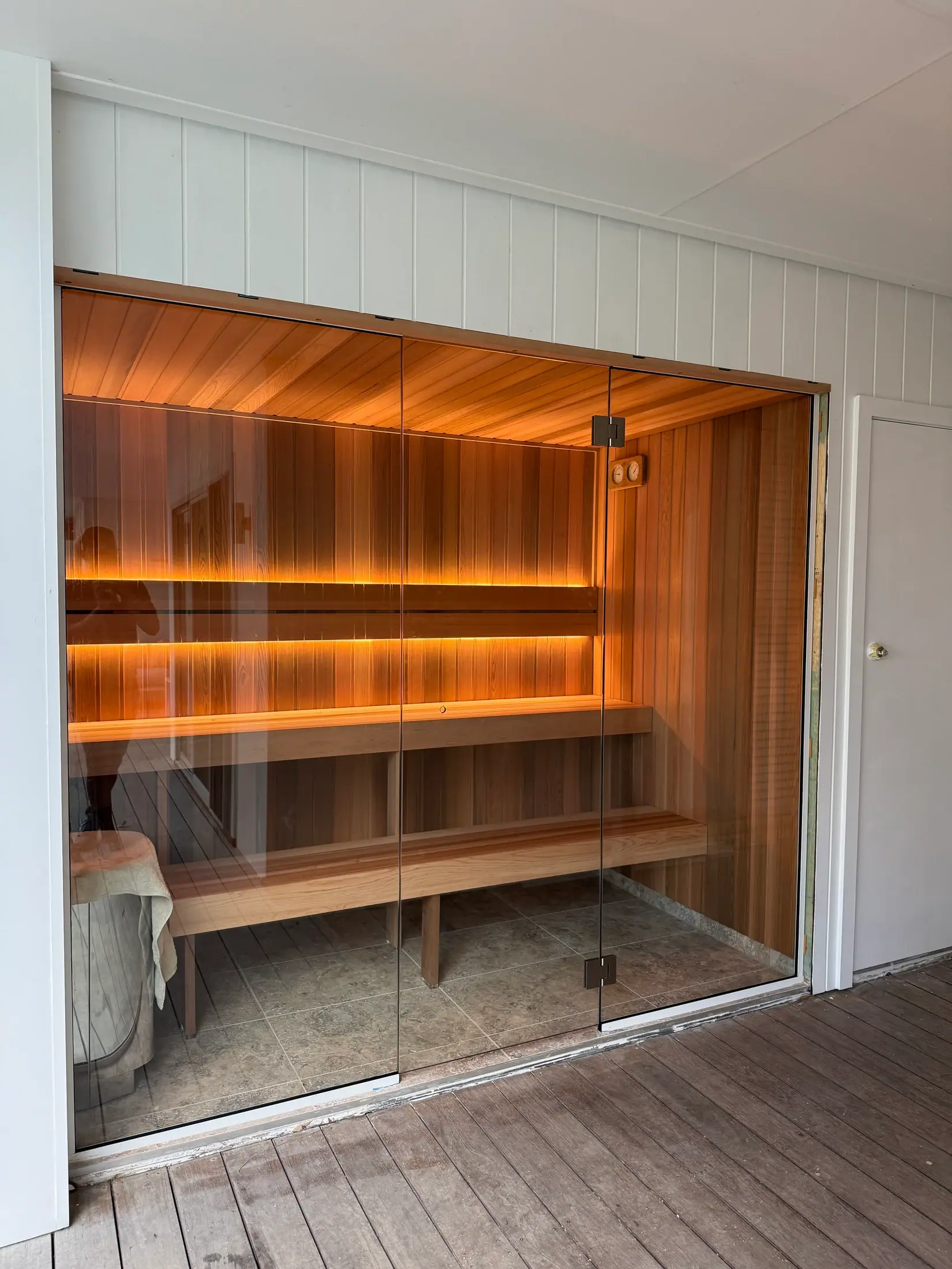 Full glass-fronted Nelsons Bay sauna with cedar benches and warm backrest lighting