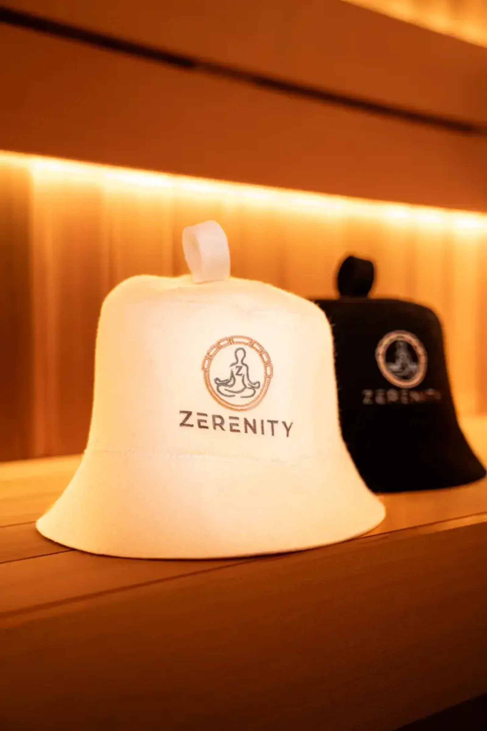 White and black Zerenity wool sauna hats with the embroidered mark
